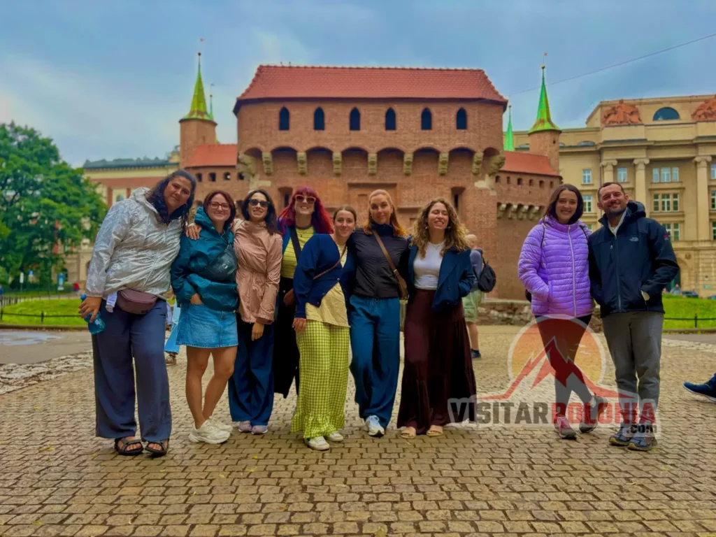 Tres grupos españoles durante el recorrido del 12 de julio de 2026 en Cracovia, caminando bajo la lluvia por la ciudad medieval